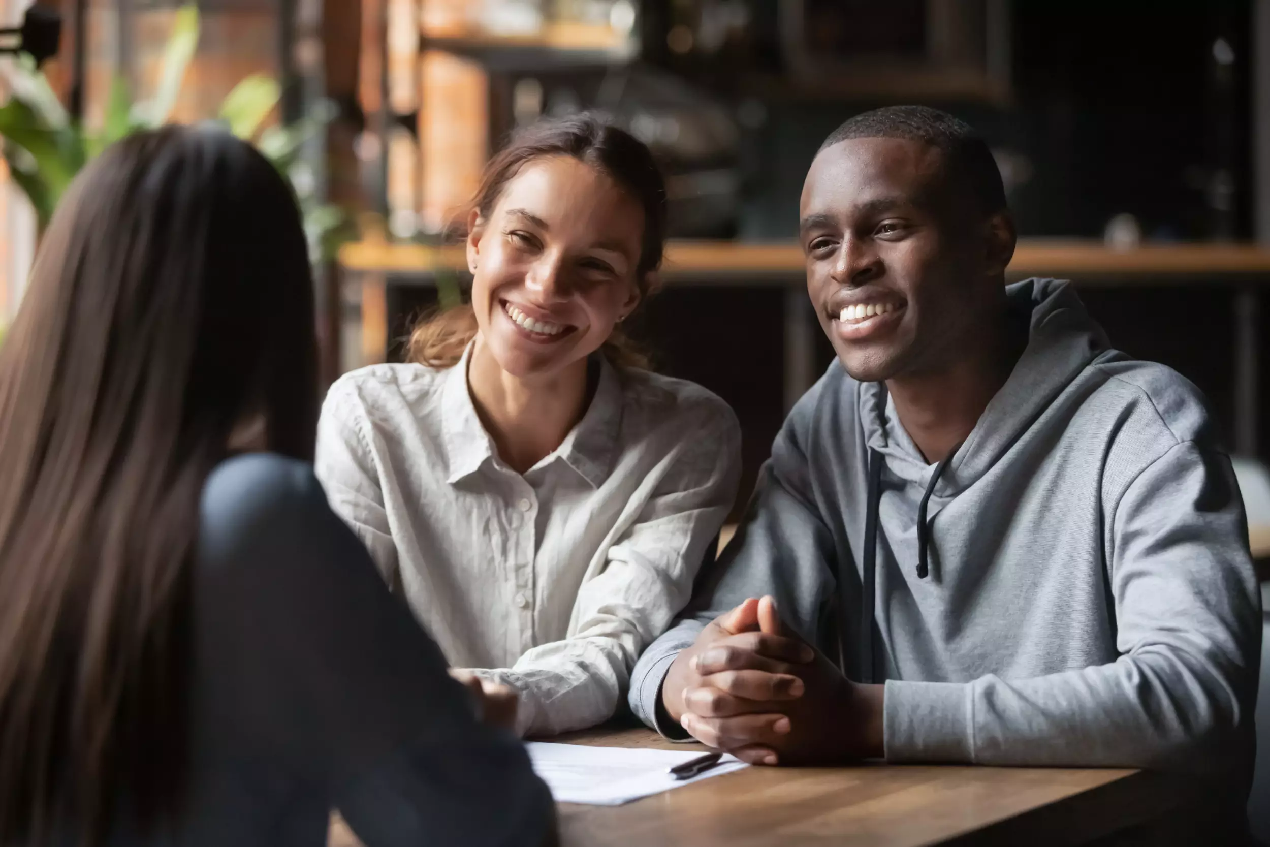 Smiling diverse couple listening to a realtor